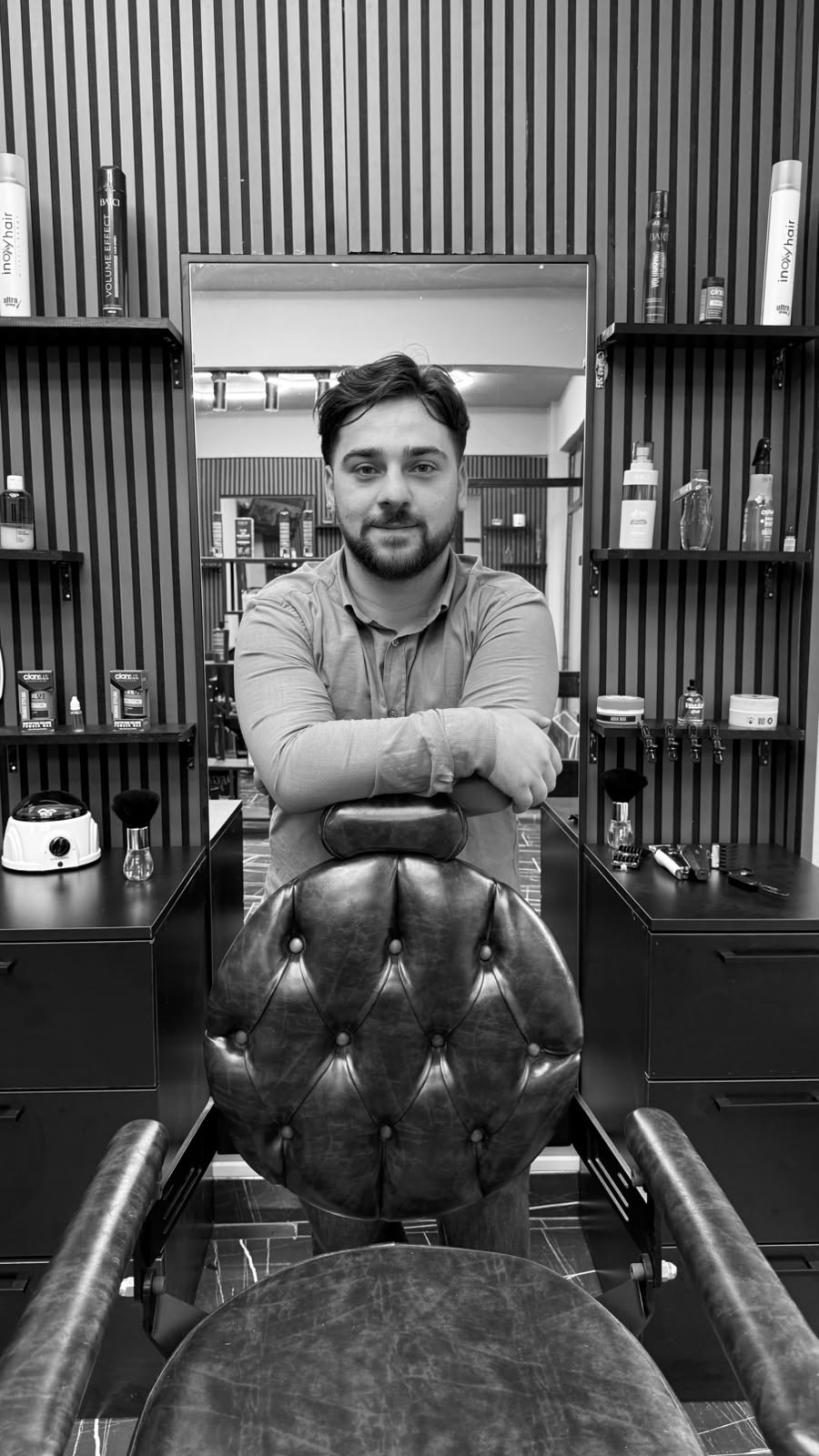 Kaan Güner, dükkânda berber koltuğunun arkasında